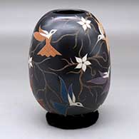 A polychrome jar decorated with a sgraffito and painted hummingbird, flower and vine design
 by Elicena Cota of Mata Ortiz and Casas Grandes