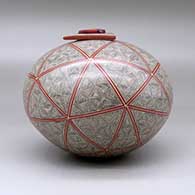 A polychrome seed pot with a triangular lid with an inlaid stone, all decorated with a spiral fineline and geometric design, click or tap to see a larger version