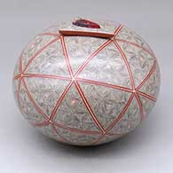 A polychrome seed pot with a triangular lid with an inlaid stone, all decorated with a spiral fineline and geometric design
 by Oralia Lopez of Mata Ortiz and Casas Grandes