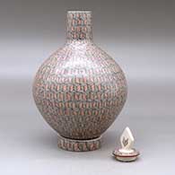 A polychrome medium necked lidded jar with a custom matching stand, all decorated with a fineline geometric design, click or tap to see a larger version