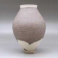 A polychrome jar with a flared lip and decorated with a painted geometric design and a lightly carved geometric design around the base, with a custom matching stand, click or tap to see a larger version