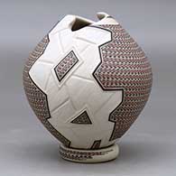 A polychrome jar with a geometric cut opening and decorated with a lightly carved, sgraffito and painted geometric design, with a custom matching stand, click or tap to see a larger version