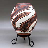 A polychrome jar decorated with a three panel lightly carved and painted sickle, bird element and geometric design, click or tap to see a larger version