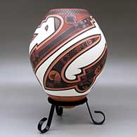 A polychrome jar decorated with a three panel lightly carved and painted sickle, bird element and geometric design, click or tap to see a larger version