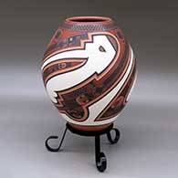 A polychrome jar decorated with a three panel lightly carved and painted sickle, bird element and geometric design
 by Tavo Silveira of Mata Ortiz and Casas Grandes