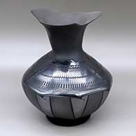 A black on black jar with an organic rim, octagonal base and decorated with a painted and sgraffito feather and geometric design
 by Susy Martinez of Mata Ortiz and Casas Grandes