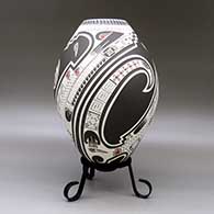 A polychrome jar lightly carved and painted with a three panel serpent, bird element, sickle and geometric design, click or tap to see a larger version