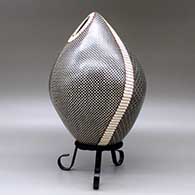 A polychrome egg-shaped seed pot decorated with a four panel checkerboard and geometric design, click or tap to see a larger version