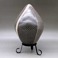 A polychrome egg-shaped seed pot decorated with a four panel checkerboard and geometric design, click or tap to see a larger version