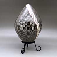 A polychrome egg-shaped seed pot decorated with a four panel checkerboard and geometric design, click or tap to see a larger version