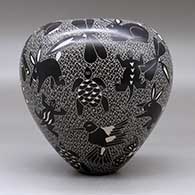 A black on white jar decorated with a sgraffito wildlife and mesh design, click or tap to see a larger version