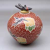 A polychrome jar decorated with a sgraffito and painted hummingbird, flower and geometric mesh design, plus a hummingbird lid
 by Vidal Corona of Mata Ortiz and Casas Grandes