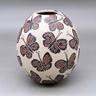 A polychrome jar decorated with a sgraffito and painted butterfly and geometric mesh design
 by Leticia Ledezma of Mata Ortiz and Casas Grandes
