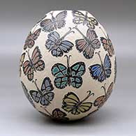 A polychrome jar decorated with a sgraffito and painted butterfly design, click or tap to see a larger version