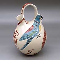 A polychrome wedding vase decorated with a lightly carved, sgraffito and painted two panel parrot, serpent and geometric design
 by Vidal Corona of Mata Ortiz and Casas Grandes