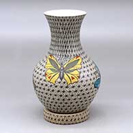 A polychrome vase with a recurved neck and decorated with a butterfly and mesh design, plus a custom matching stand
 by Olga Arras of Mata Ortiz and Casas Grandes