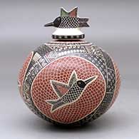 A polychrome jar decorated with a sgraffito and painted hummingbird, mesh and geometric design, with a matching hummingbird lid, click or tap to see a larger version