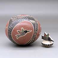 A polychrome jar decorated with a sgraffito and painted hummingbird, mesh and geometric design, with a matching hummingbird lid, click or tap to see a larger version