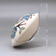 A polychrome seed pot decorated with a lightly carved, sgraffito and painted hummingbird, vine, flower and berry design, click or tap to see a larger version