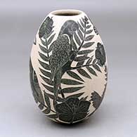 A black on white jar decorated with a four panel sgraffito bird, butterfly, branch, leaf and flower design
 by Guadalupe Rodriguez of Mata Ortiz and Casas Grandes