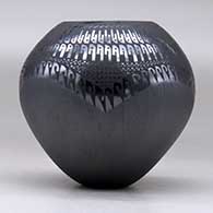 A black on black jar decorated with a geometric design, click or tap to see a larger version