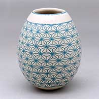 A teal on beige jar decorated with a geometric mesh design
 by Lencho Sanchez Jr of Mata Ortiz and Casas Grandes