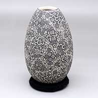A black-on-white vase with a sgraffito geometric design
 by Hector Javier Martinez of Mata Ortiz and Casas Grandes