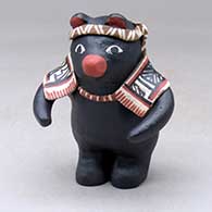 A polychrome black bear figure wearing a headband and a shawl
 by Denise Eustace of Cochiti