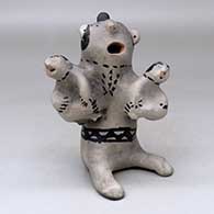 A polychrome storyteller figure holding two children
 by Unknown of Cochiti