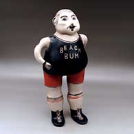 A standing polychrome Beach Bum figure, with lollipop
 by M Janice Ortiz of Cochiti