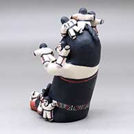 A sitting grandmother storyteller figure with fifteen children on her, click or tap to see a larger version