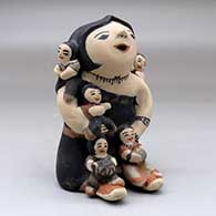A sitting grandmother storyteller figure with five children
 by Felicita Eustace of Cochiti