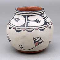 A small polychrome jar decorated with a rainbird, cloud and geometric design 
 by Seferina Ortiz of Cochiti