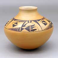 A black on yellow jar with a four-panel bird element and geometric design above the shoulder and below the neck
 by Garrett Maho of Hopi