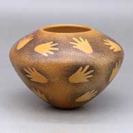 A black on yellow seed pot decorated with a hand and splatter pattern design
 by Garrett Maho of Hopi