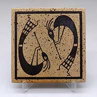 A black on yellow tile decorated with a kokopelli and geometric design
 by Stetson Setalla of Hopi