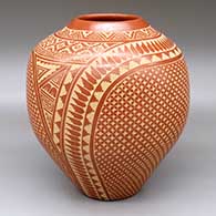 A red jar with a two-panel sgraffito snowflake, feather, scroll and geometric design
 by Wilma Baca Tosa of Jemez