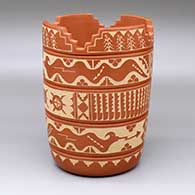 A red prayer cylinder decorated with a lightly carved and sgraffito five-band design with avanyu, turtle, corn plant, feather and geometric elements
 by Alvina Yepa of Jemez