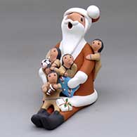 A sitting Santa Claus storyteller figure with five children and gifts
 by Diane Lucero of Jemez