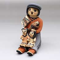 A sitting grandfather storyteller figure with three children
 by Chrislyn Fragua of Jemez