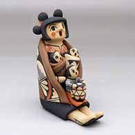A sitting grandmother storyteller figure with a manta and three children
 by Chrislyn Fragua of Jemez