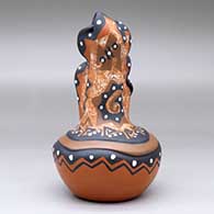 A polychrome mudhead storyteller with two children on top of a carved and painted jar, click or tap to see a larger version