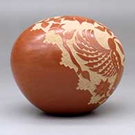 A red seed pot decorated with a sgraffito hummingbird, flower and vine design, click or tap to see a larger version