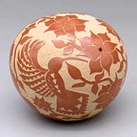 A red seed pot decorated with a sgraffito hummingbird, flower and vine design
 by Alvina Yepa of Jemez