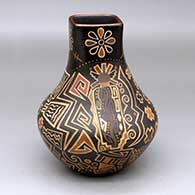 A polychrome jar with a squarish opening and decorated with a lightly-carved and painted Barrier Canyon figure, dragonfly, flower, snowflake and geometric design
 by Glendora Fragua of Jemez