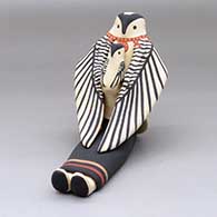 A sitting owl storyteller figure with one chick
 by Loren Wallowing Bull of Jemez