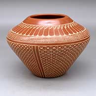 A high-shouldered red jar decorated with a sgraffito scroll, feather, snowflake and geometric design
 by Wilma Baca Tosa of Jemez