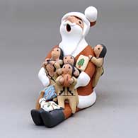 A sitting Santa Claus storyteller figure with five children and some gifts
 by Diane Lucero of Jemez