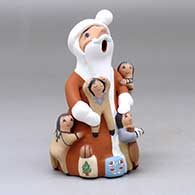 A standing Santa Claus storyteller figure with four children and some gifts
 by Diane Lucero of Jemez