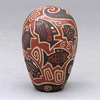 A polychrome seed pot decorated with a lightly carved and painted fish, sun, flower and geometric design, click or tap to see a larger version